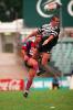 Andrew Johns gets a kick away despite an attempted charge-down.
