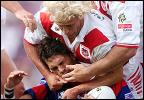 Jason Moodie is tackled by Nathan Brown.