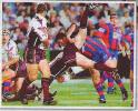 Andrew Johns thumps an Eagles player.