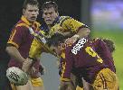 Danny Buderus tackling again while Josh Perry looks on.