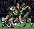 Dane Carlaw is tackled with Danny Buderus watching.