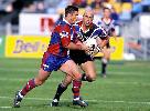 Andrew Johns runs the ball.