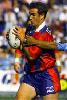 Andrew Johns evades a tackle.