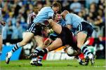 Steve Simpson and others make a tackle.