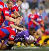 Marcus Bai is tackled by half the side.