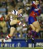Brad Fittler gets a kick away despite an attempted charge-down.