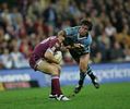 Cory Parker is wrapped up by Andrew Johns.