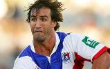 Andrew Johns making a pass.