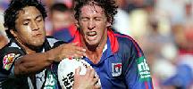Kurt Gidley tries to shrug off a tackle ...
