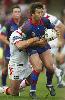 Andrew Johns is tackled by the Dragons.