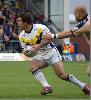 Andrew Johns gets away from a Leeds defender.