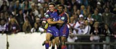 Danny Buderus and Milton Thaiday celebrate a try.