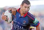 Andrew Johns runs the ball.