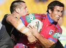 Andrew Johns gets crunched.
