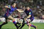 Travis Burns dives between Buderus and Kurt Gidley.