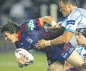 ... with Cronulla defenders clinging to him.