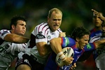 Kurt Gidley is taken down by Jamie Lyon and Steve Bell.