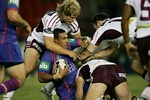 Cooper Vuna is all wrapped up by some half-decent Manly defence.
